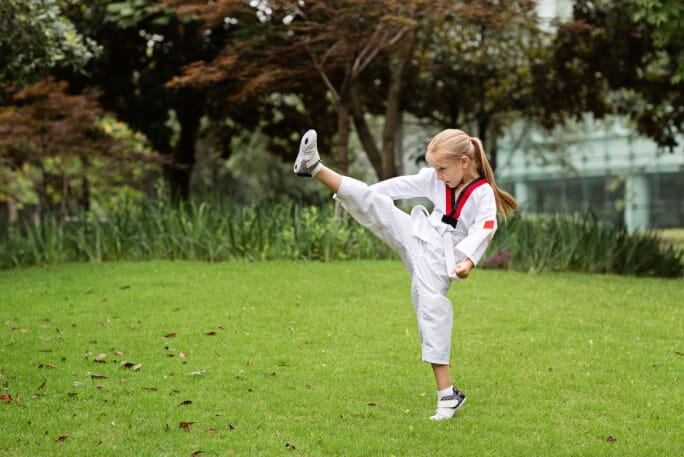Menina a praticar artes marciais ao ar livre