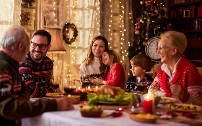 Família reunida à mesa com um menu de Natal delicioso  