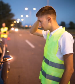 Homem com colete refletor, observa o acidente automóvel que envolve o seu carro
