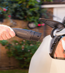 Homem a carregar carro elétrico em casa, depois de aprender como montar o home charger