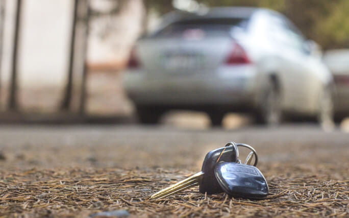 Chaves caídas na rua, dando a entender que alguém perdeu as chaves do carro.