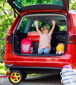 Crianças a brincar dentro de um carro antes de irem de férias