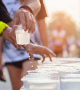 Grupo de atletas de corrida a pegar em copos de água