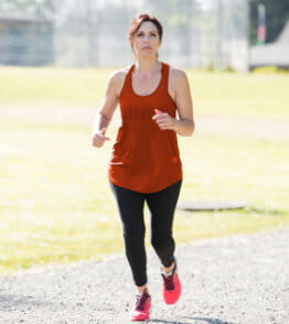 Mulher a correr no exterior e a treinar para uma maratona