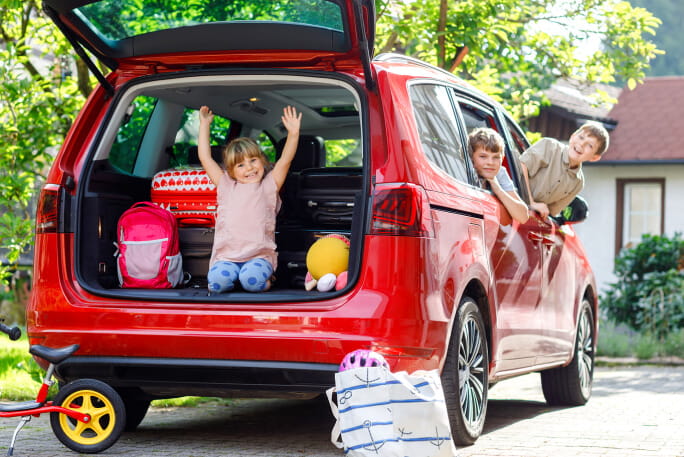 Crianças a brincar dentro de um carro antes de irem de férias
