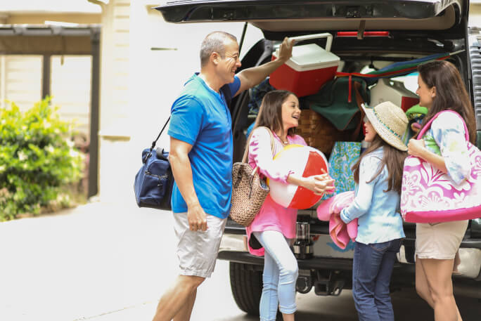 Uma família prepara-se para viajar de carro nas férias de verão.