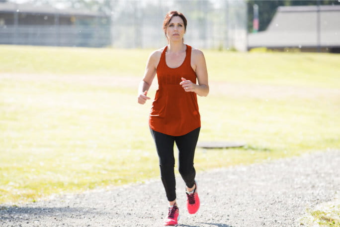 Mulher a correr no exterior e a treinar para uma maratona