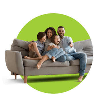 Casal e dois filhos sentados no sofá de casa