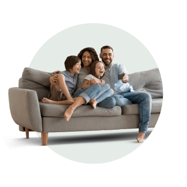 Casal e dois filhos sentados no sofá de casa