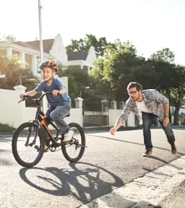 Pai ensina o filho a andar de bicicleta