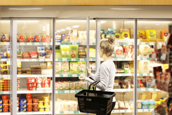 Mulher jovem, com intolerância alimentar, faz compras no supermercado. 